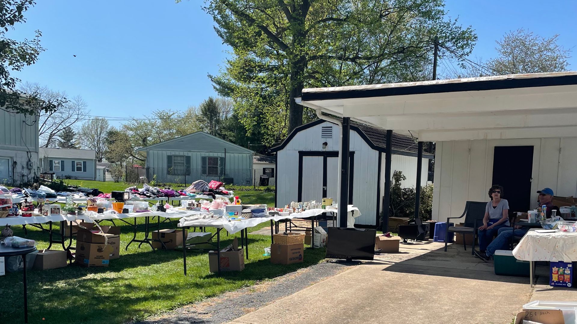a yard sale for Steadfast on a bright sunny day with two people sitting at a table