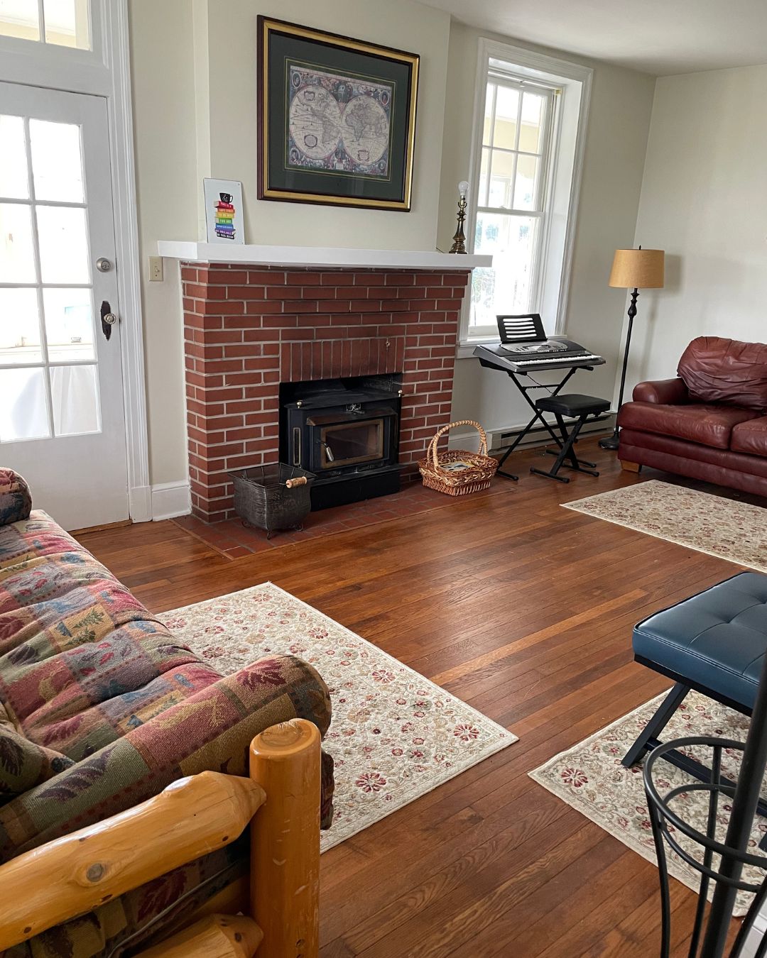 photo of library fireplace with wooden floors, door to sunroom, area rugs, electric keyboard